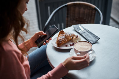 Midsection of woman holding coffee cup