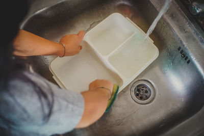 Close-up of woman cleaning plate at home