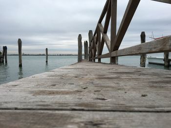 Pier on sea against cloudy sky