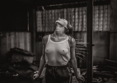 Sensuous woman standing in abandoned building