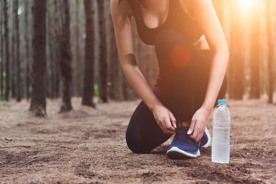 Midsection of woman holding hands in forest