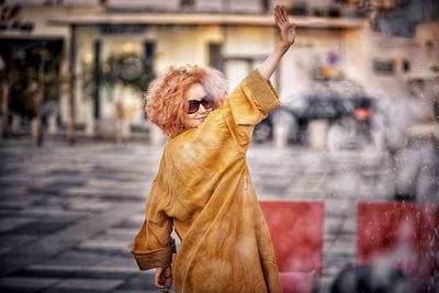 Portrait of woman wearing sunglasses standing in city