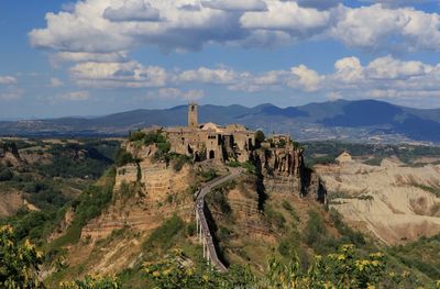 Castle on mountain against cloudy sky