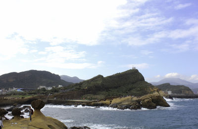 Scenic view of sea and mountains against sky