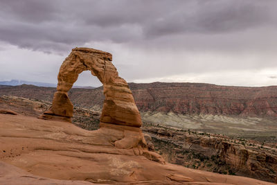 Rock formations on landscape against sky at delicate arch