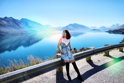 Full length of woman standing on mountain lake