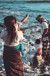Rear view of two women standing in sea