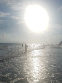 Silhouette people on beach against sky