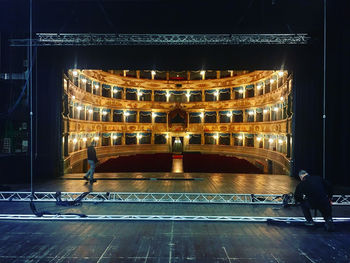 Rear view of people standing at night