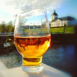 Close-up of beer on table against sky