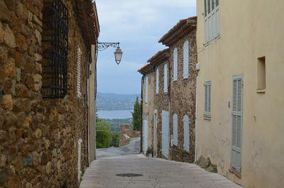 Road amidst houses against sky