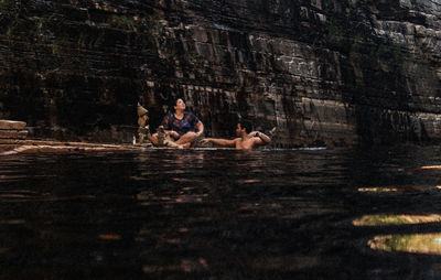 People sitting by lake