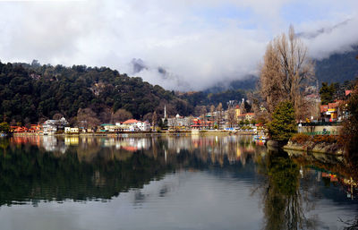Scenic view of lake by buildings against sky