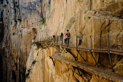 People on cliff against mountains