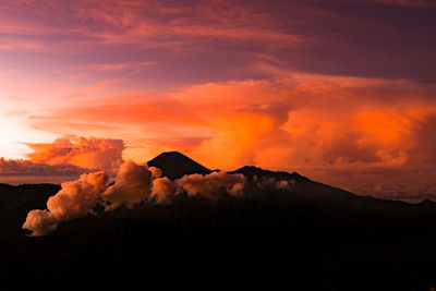 Scenic view of volcanic mountain against sky during sunset