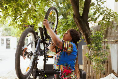 Portrait of woman with bicycle on street