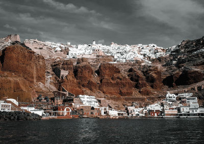 Buildings by sea against sky