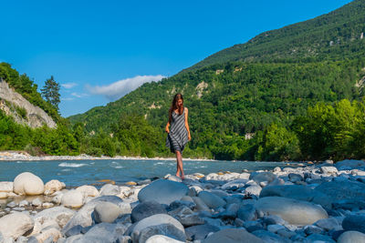 Man standing on rocks against sky