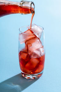 Close-up of ice pouring in glass