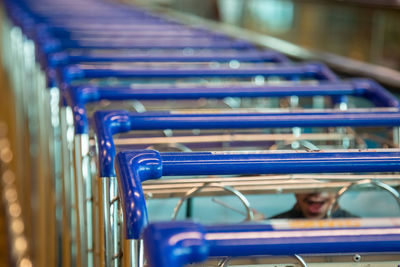 Row of shopping trolleys close-up blue handles