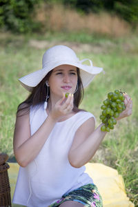 Woman eating grapes on blanket in picnic