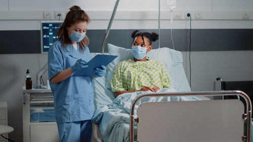 Nurse examining female patient at clinic