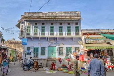 People on street against buildings in city