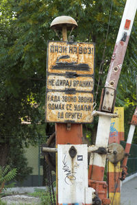 Information sign on plant against trees