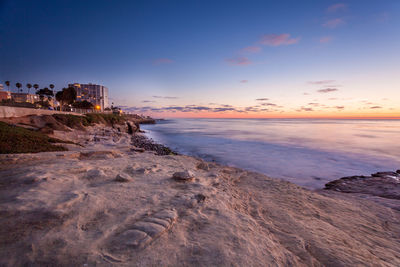 Scenic view of beach against sky during sunset