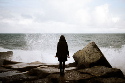 Rear view of woman standing on beach