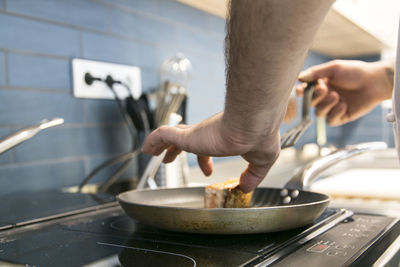 Midsection of man preparing food in kitchen