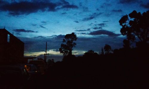 Silhouette of trees against cloudy sky