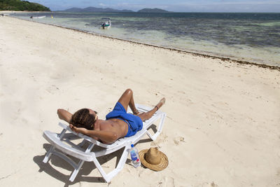 Man lying down on sand at beach