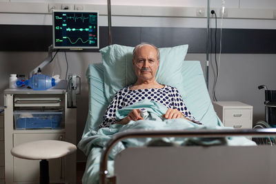 Portrait of a man sitting on bed