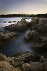 Rocks on beach against sky