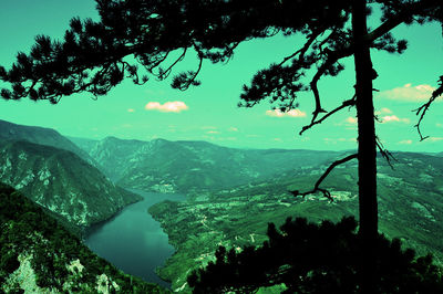 Scenic view of lake by mountains against sky