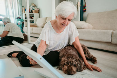 Woman with dog working on wood at home