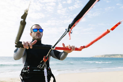 Full length of man holding umbrella on beach