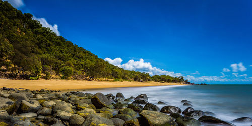 Scenic view of sea and mountains against blue sky