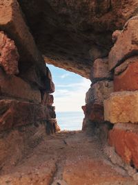 Rock formation on beach against sky