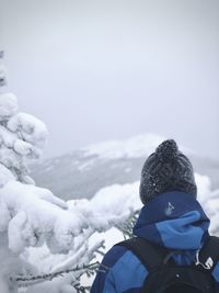 Man with snow in mountains against sky