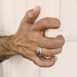 Cropped hand of man holding wooden cabinet at home