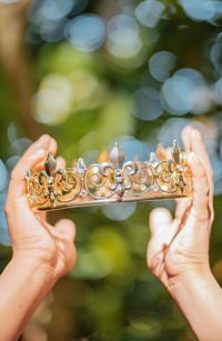 Close-up of woman holding crown outdoors