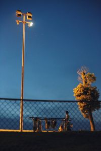 Tilt-shift image of illuminated floodlight against sky