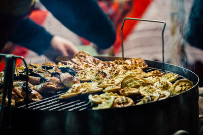 Cropped hands preparing food on barbecue grill