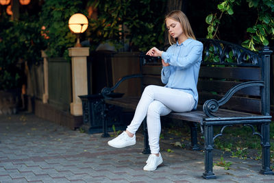 Full length of young woman using mobile phone