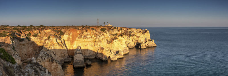 Rock formations by sea against sky