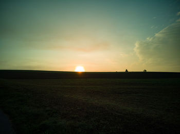 Scenic view of field against sky during sunset