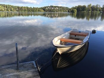 Boat moored in lake against sky