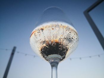 Low angle view of glass against blue sky